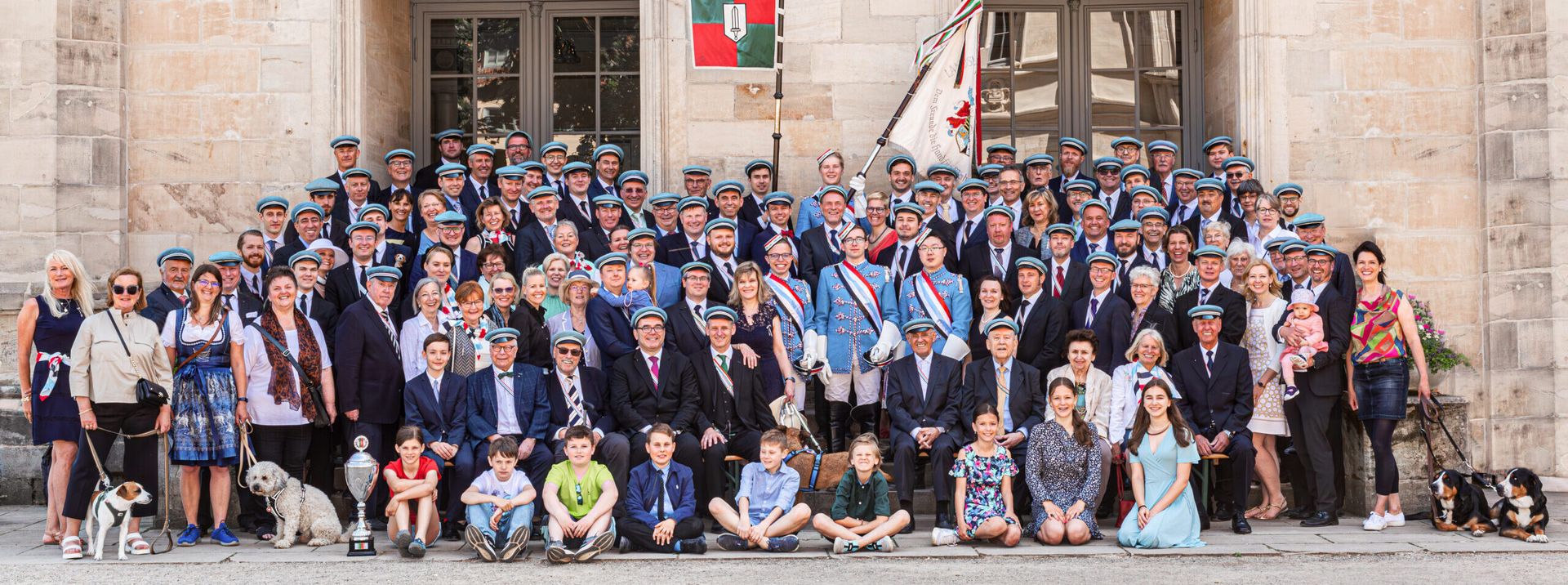 Großes Gruppenbild der Saxo-Suevia mit Aktiven, Alten Herren, Damen und Kindern vor einem Sandsteingebäude in Coburg